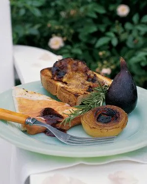 Martha Stewart balsamic fig sauce spooned over toasted bread and a pastry slice on a green plate with a fresh fig and rosemary