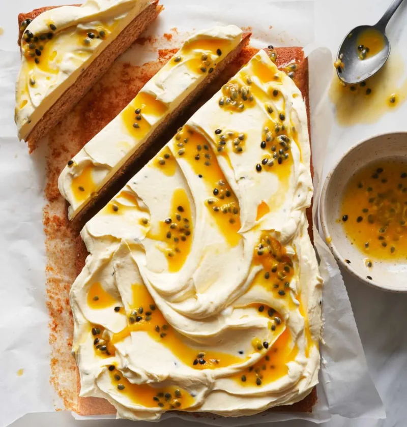 Martha Stewart banana sheet cake with passion-fruit frosting swirled with passion-fruit pulp and cut into slices on parchment