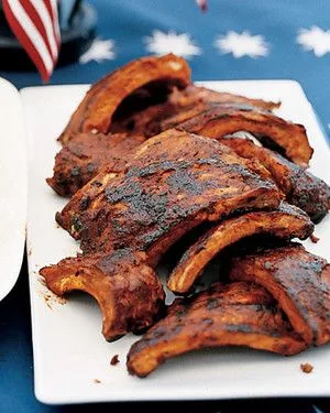 Martha Stewart barbecued baby-back ribs with a dark barbecue glaze piled on a white platter
