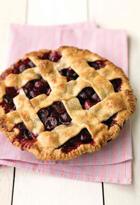 Martha Stewart basic pie dough for sweet cherry pie baked into a golden lattice crust over dark cherry filling