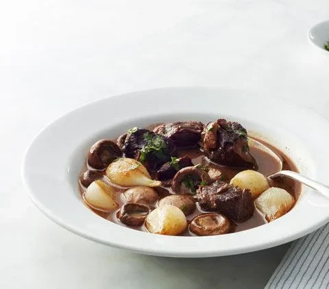 Martha Stewart beef Bourguignon in a white bowl with tender beef, glazed pearl onions and mushrooms in a red wine sauce