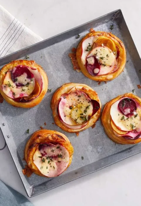 Martha Stewart beet, cheddar and apple tarts with sliced beet and apple on golden puff pastry on a metal serving tray