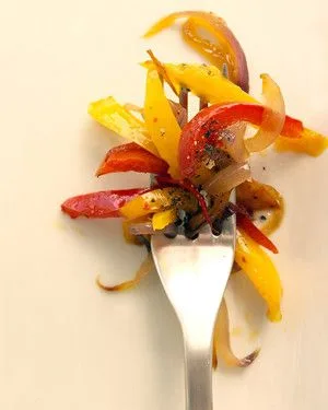 Martha Stewart bell pepper saute with red and yellow pepper strips and red onion twirled on a fork