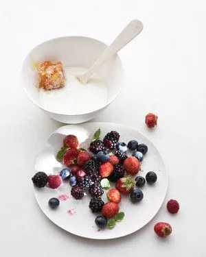 Martha Stewart berries with buttermilk and honey: a plate of mixed berries and mint beside a bowl of frothy buttermilk with a honeycomb piece