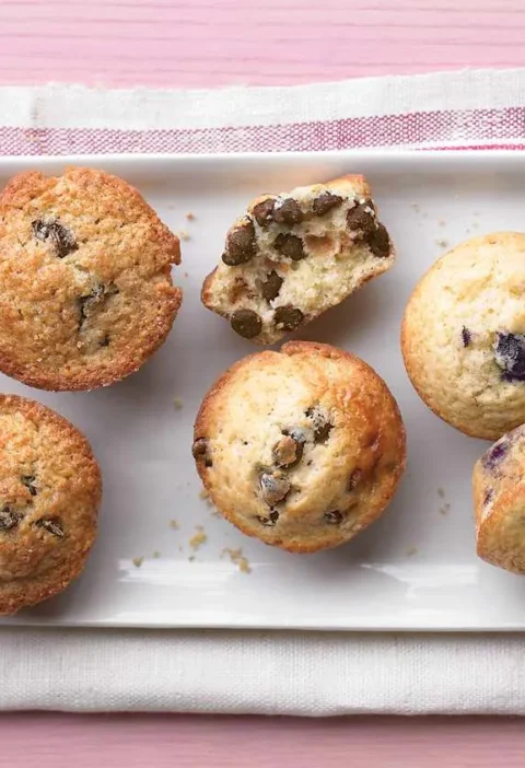 Martha Stewart Better-Than-Basic Muffins in blueberry, chocolate chip, corn and cherry-pecan varieties on a white platter