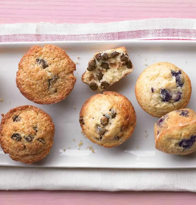 Martha Stewart Better-Than-Basic Muffins in blueberry, chocolate chip, corn and cherry-pecan varieties on a white platter