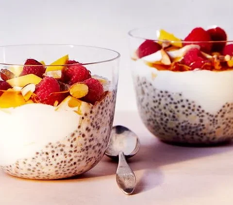 Martha Stewart Bircher chia parfait in glass cups layered with chia oats, yogurt, mango, raspberries and almonds