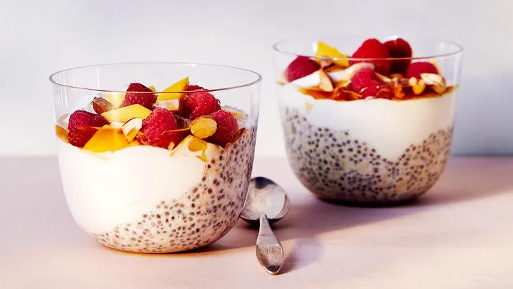 Martha Stewart Bircher chia parfait in glass cups layered with chia oats, yogurt, mango, raspberries and almonds