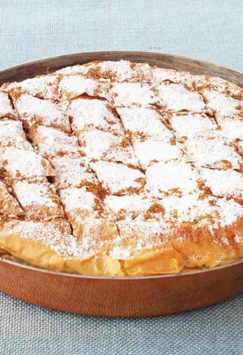 Martha Stewart bisteeya, a golden phyllo pie scored in a diamond pattern and dusted with confectioners' sugar in a round copper pan