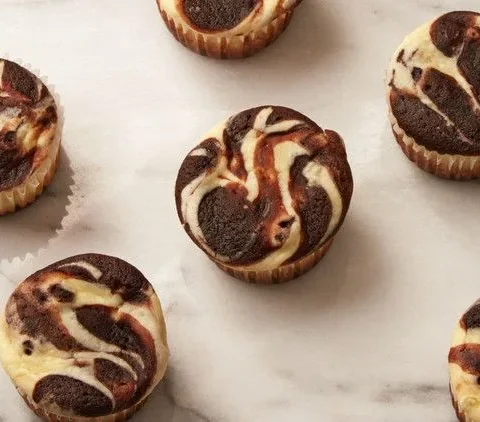 Martha Stewart black bottom cupcakes with a marbled chocolate and cream cheese top on a white marble surface