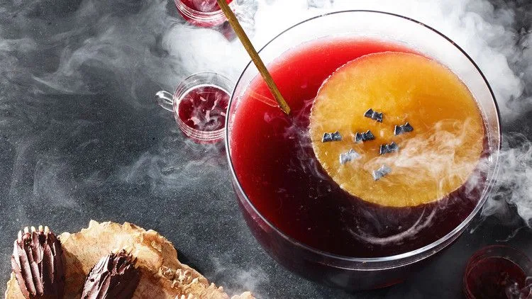 Martha Stewart Blood-Moon Punch with a frozen orange ice moon topped with candy bats floating in deep red punch
