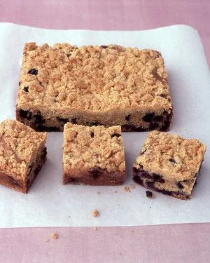 Martha Stewart blueberry crumb cake cut into squares with a golden brown streusel topping on parchment paper