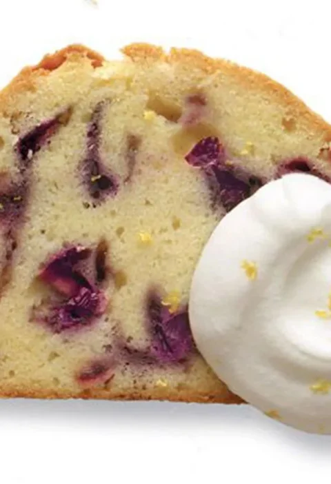 Slice of Martha Stewart blueberry-sour cream pound cake with lemon cream and lemon zest on the side