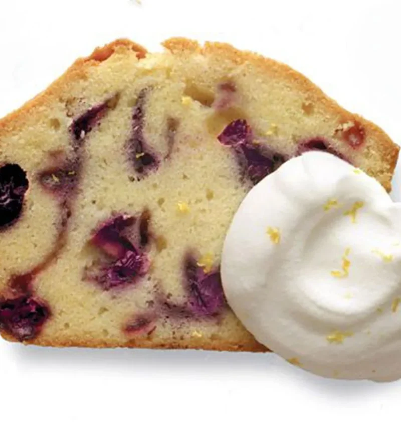 Slice of Martha Stewart blueberry-sour cream pound cake with lemon cream and lemon zest on the side