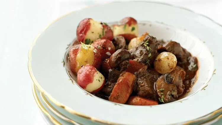 Martha Stewart boeuf bourguignon in a white bowl with beef chunks, carrots, mushrooms, pearl onions and red potatoes