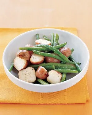 Martha Stewart boiled potatoes and green beans in a white bowl on a yellow napkin, with halved baby red potatoes and crisp-tender green beans