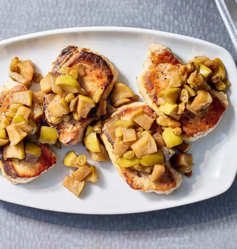 Martha Stewart boneless pork chops with apple chutney spooned over golden seared chops on a white platter