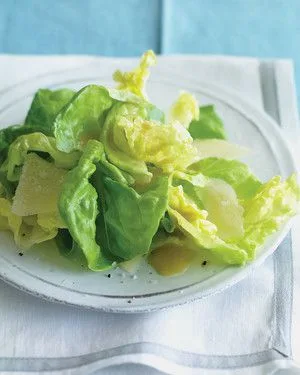 Martha Stewart Boston lettuce with shaved Parmesan on a white plate with Dijon vinaigrette