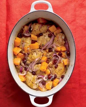 Martha Stewart braised chicken with butternut squash and cranberries with red onion in a white Dutch oven