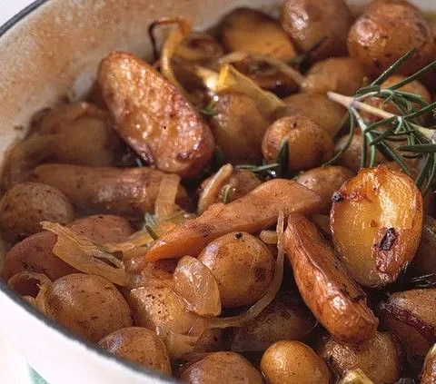 Martha Stewart braised potatoes with fingerlings, shallots and rosemary sprigs in a white skillet