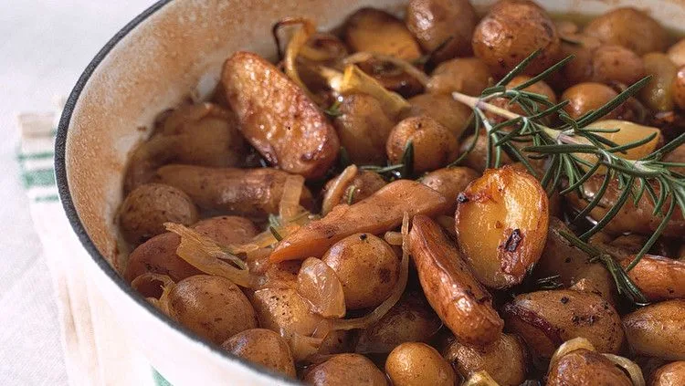 Martha Stewart braised potatoes with fingerlings, shallots and rosemary sprigs in a white skillet