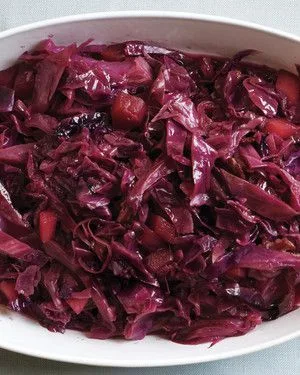 Martha Stewart braised red cabbage with apple pieces served in a white oval dish