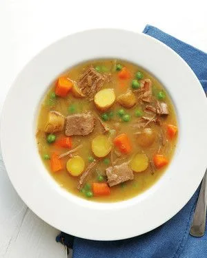 Martha Stewart brisket and potato stew with beef cubes, carrots, fingerling potatoes and peas in a white bowl
