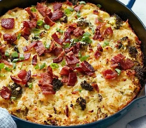 Martha Stewart broccoli-cheddar hash-brown casserole topped with crumbled bacon and sliced scallions in a cast iron skillet
