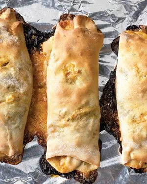 Martha Stewart broccoli, tomato and mozzarella stromboli rolls baked golden on a foil-lined baking sheet